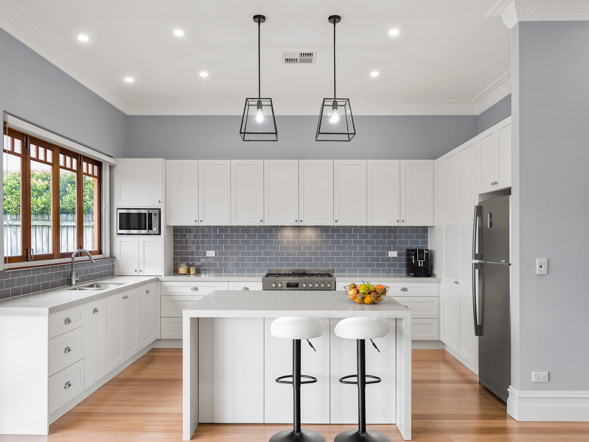 White kitchen with an island and timber-framed windows