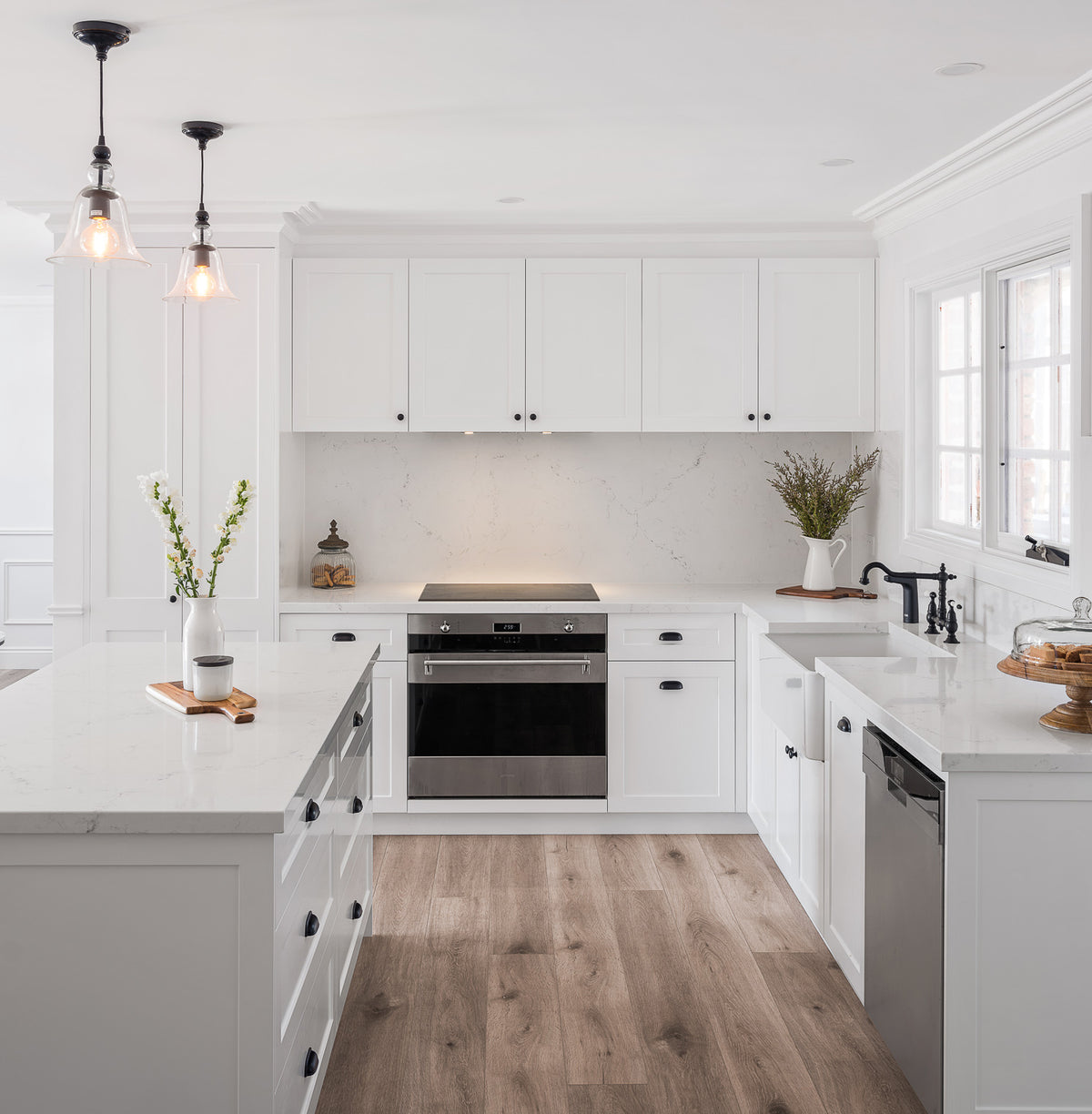 White kitchen cabinetry with a central island and oven