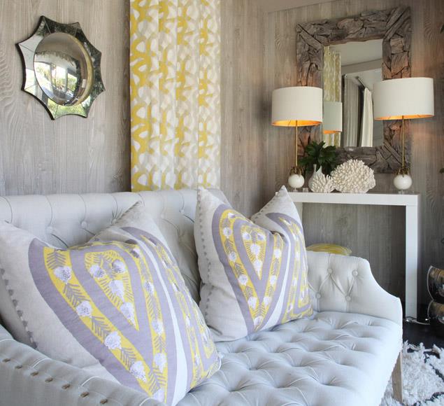 Pale sofa with yellow patterned cushions and table lamps
