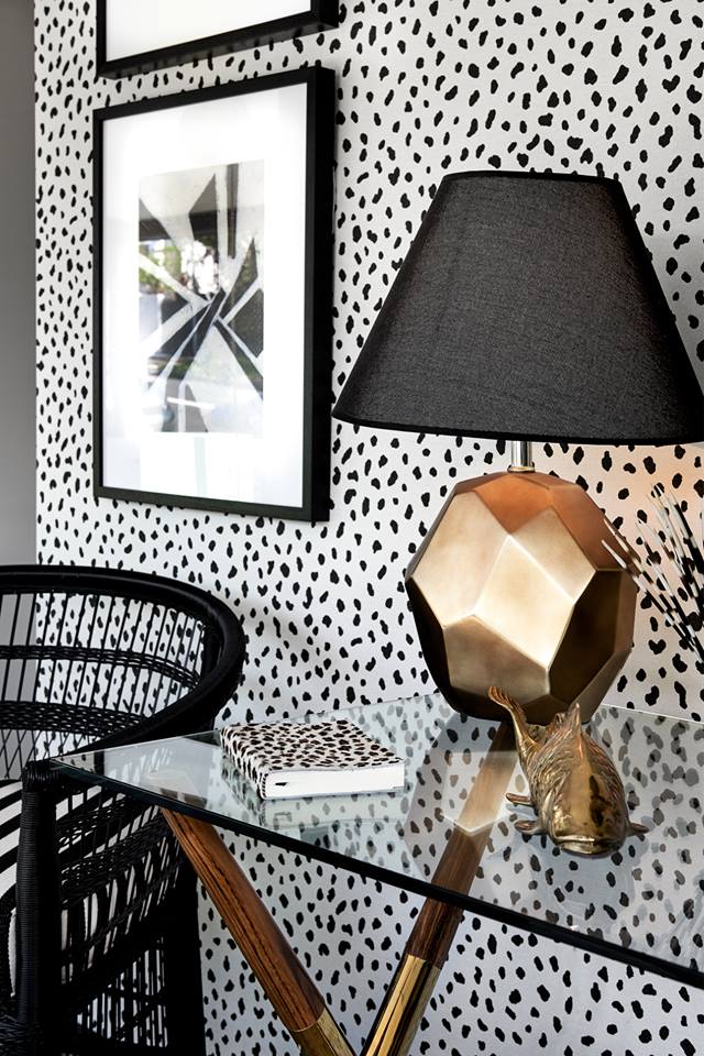 Decorative wall finish with a timber console and sculptural lighting