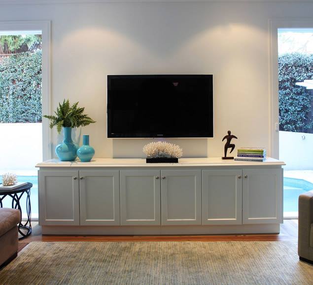 Painted cabinetry beneath a wall-mounted television