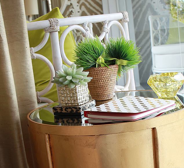 Patterned curtains beside a timber table with decorative objects