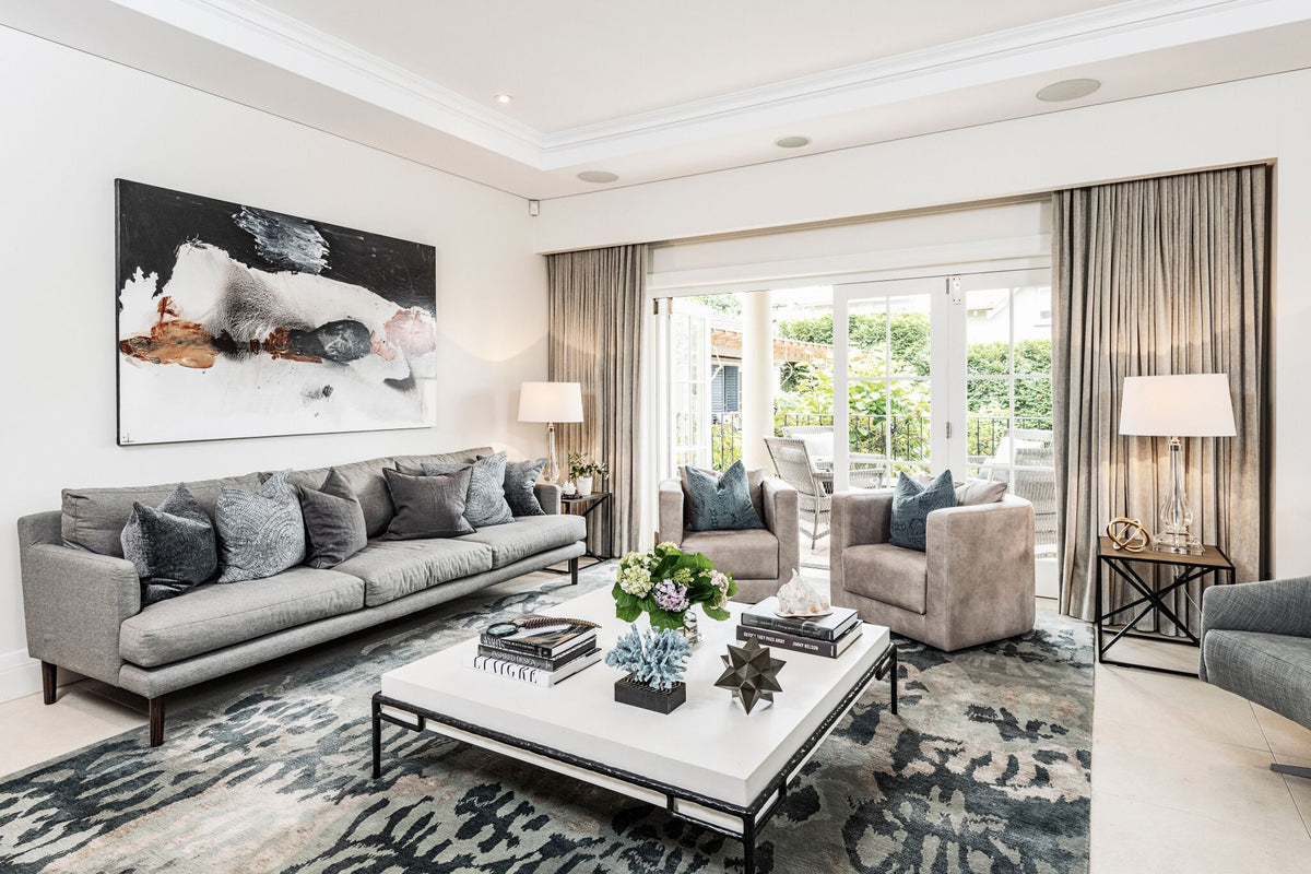 Living room with grey seating, patterned rug and garden-facing doors