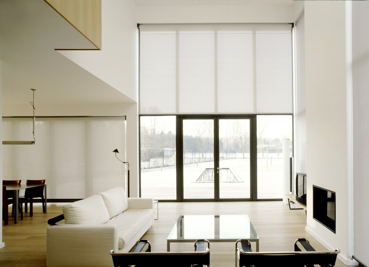 Helioscreen products: pale roller screens across tall living-room windows.