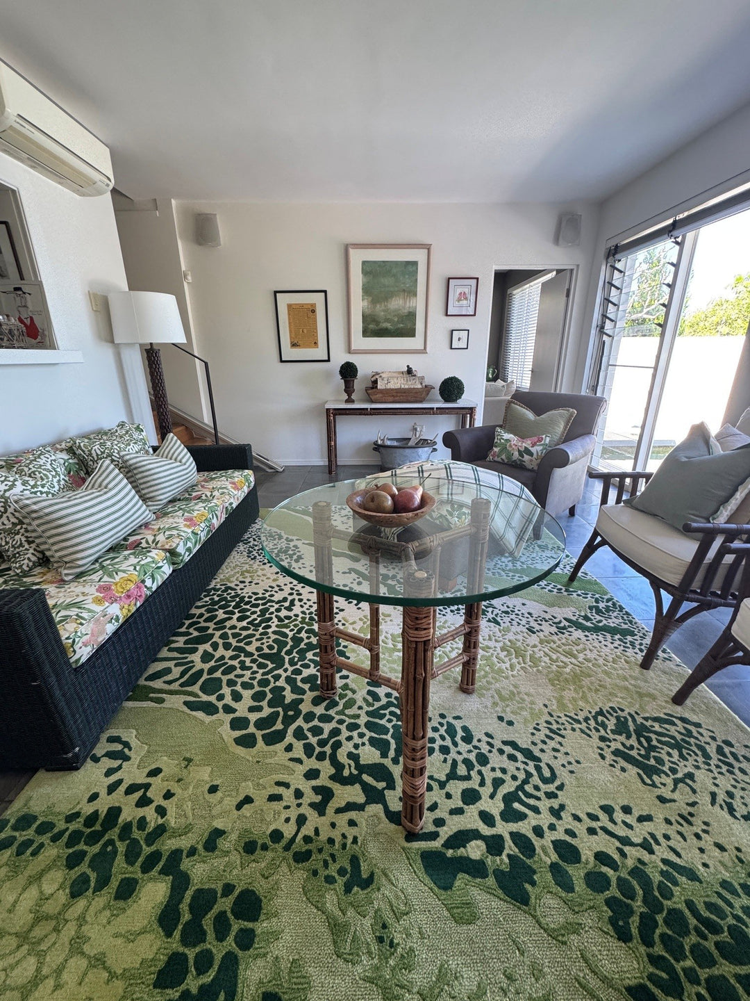 Living room combining floral seating, striped cushions and a green patterned rug