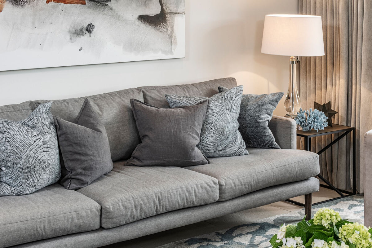 Grey sofa with cushions and a side table