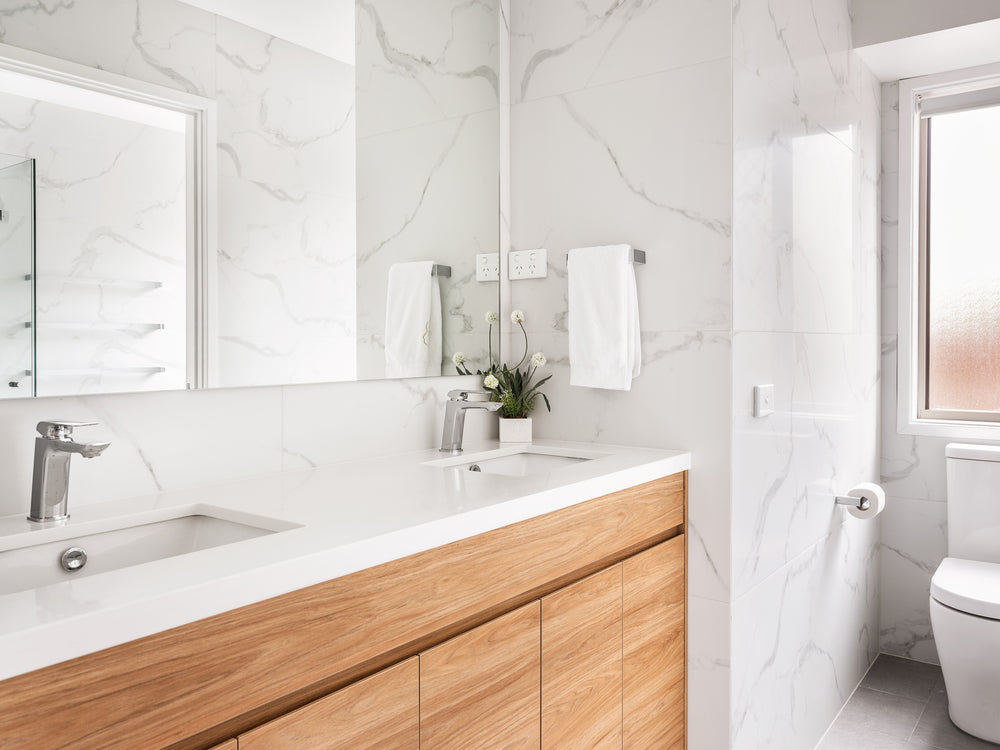 Bathroom vanity with timber drawers and a marble-look wall