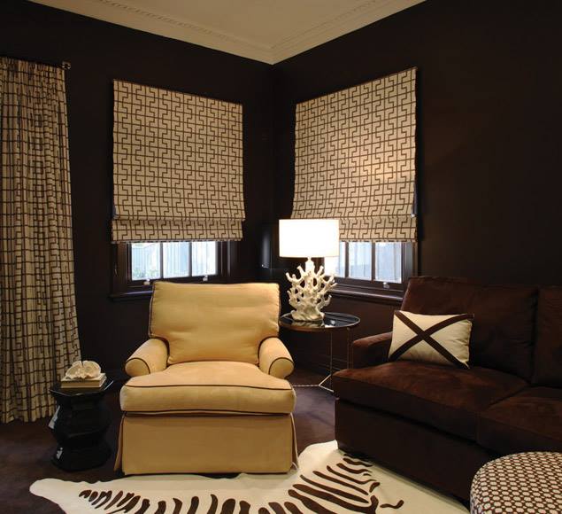 Upholstered seating beneath patterned Roman blinds