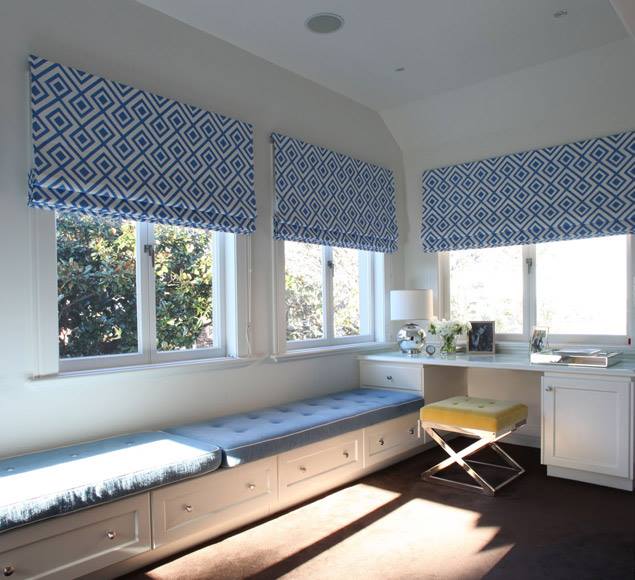 Blue patterned Roman blinds above a long window seat