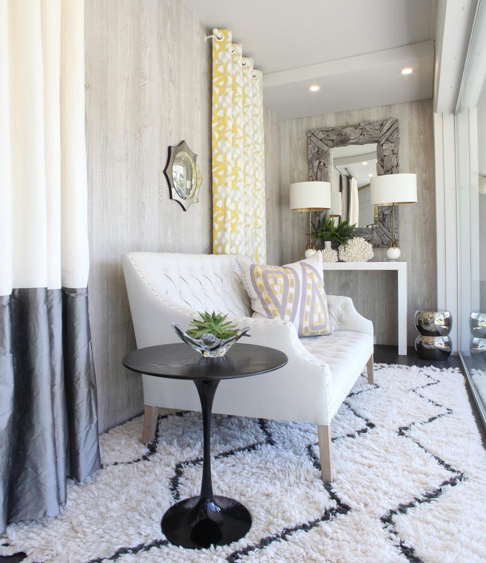Pale armchair and a small dark side table beside curtains