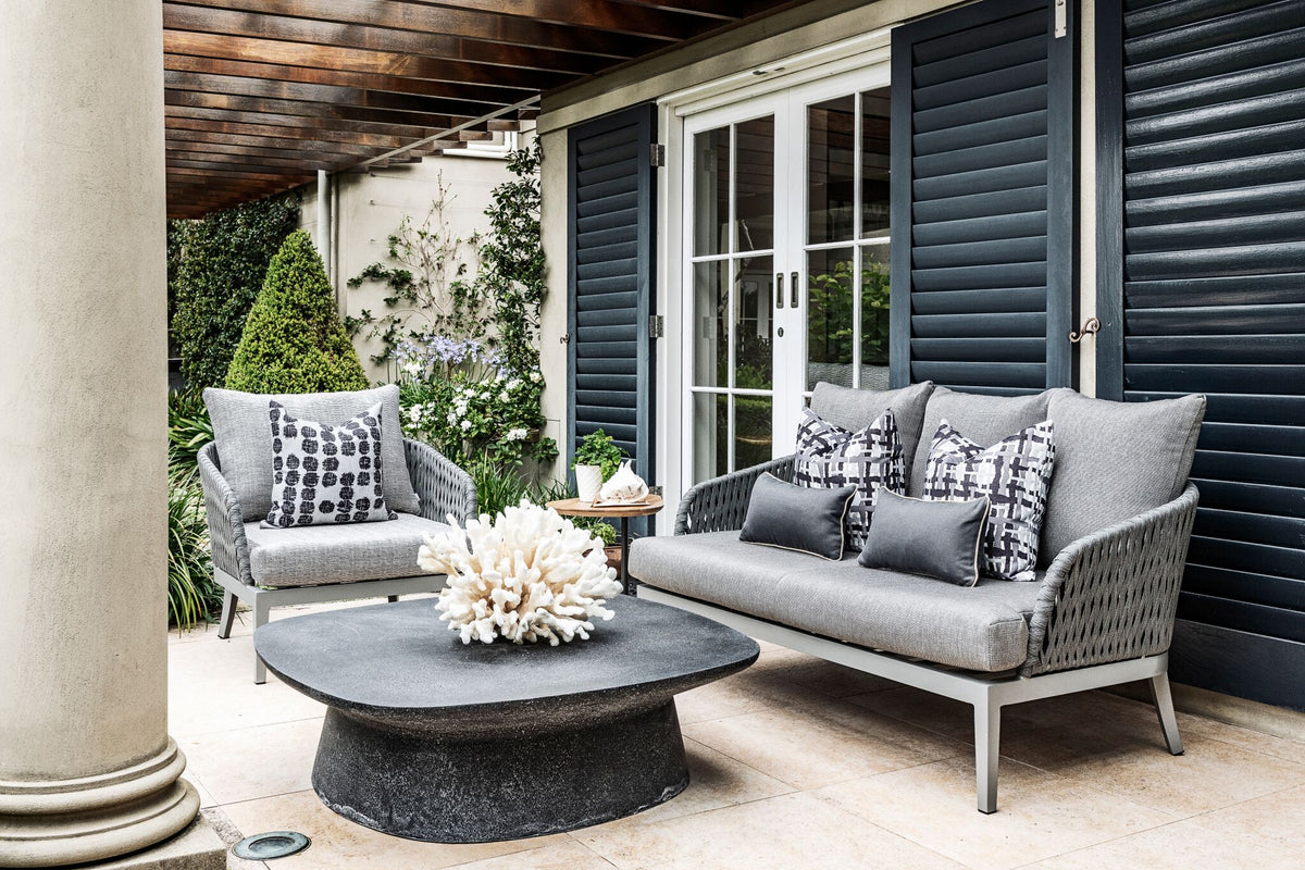 Dark louvred exterior shutters beside French doors and outdoor seating