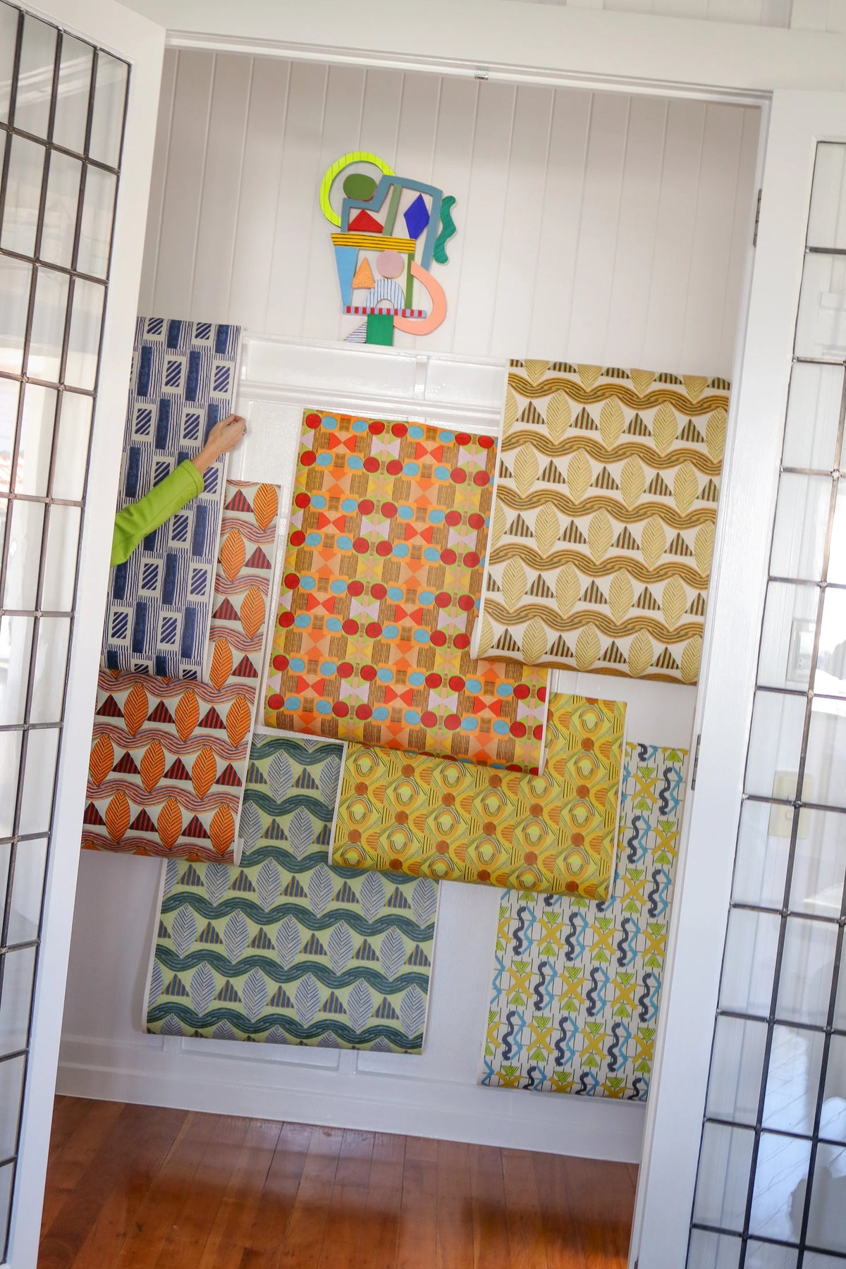 Colourful patterned sample panels displayed against a white wall