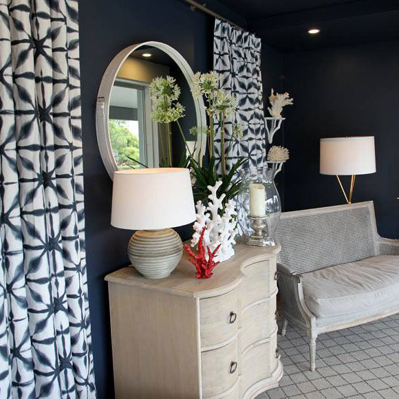 Patterned curtains beside a sofa and pale sideboard