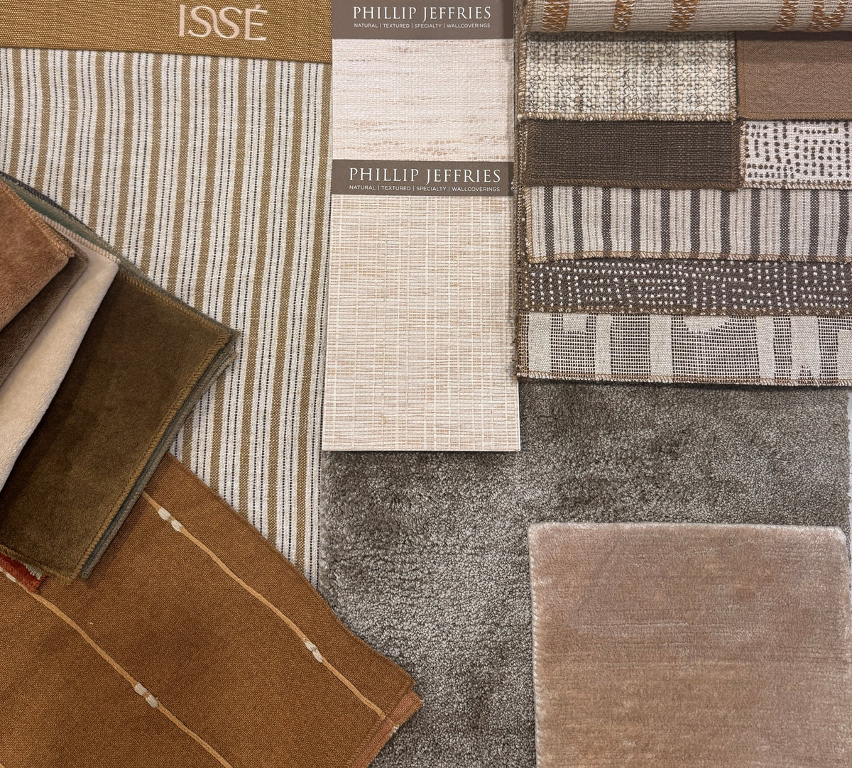 Brown, cream and grey fabric and wallcovering samples arranged as a coordinated palette