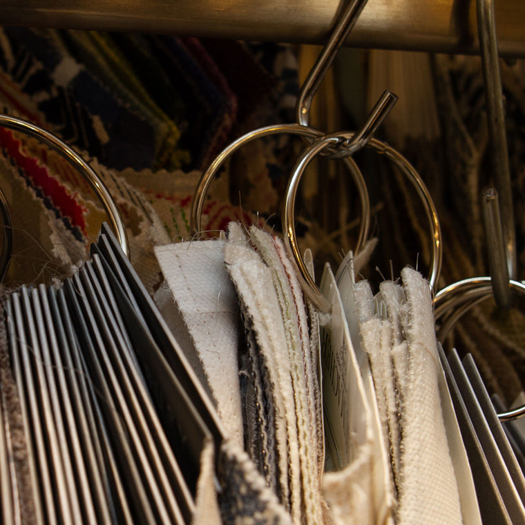Fabric swatches and sample books hanging from metal rings in Tempo’s studio library.
