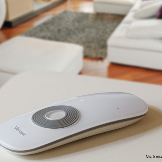Handheld remote control on a table beside upholstered seating