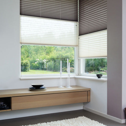 Pleated blinds covering upper and lower sections of a window