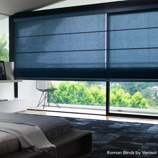 Dark Roman blind partially lowered across a bedroom window