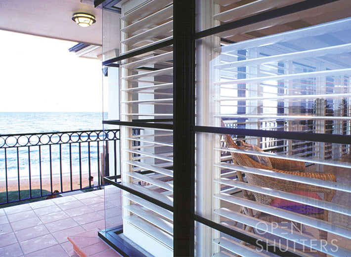 White louvred shutters beside a glazed opening and balcony