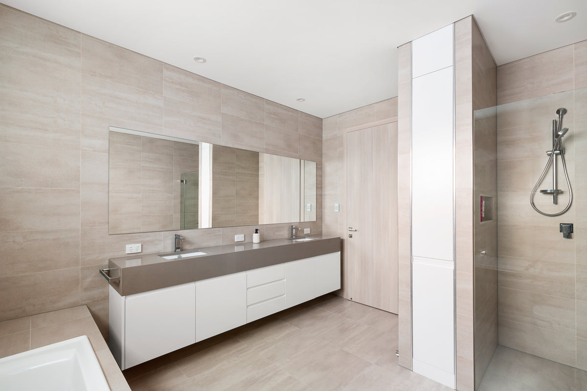 Bathroom vanity with white drawers and a large mirror