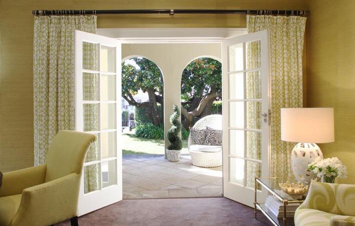 Patterned curtains framing French doors in a sitting room