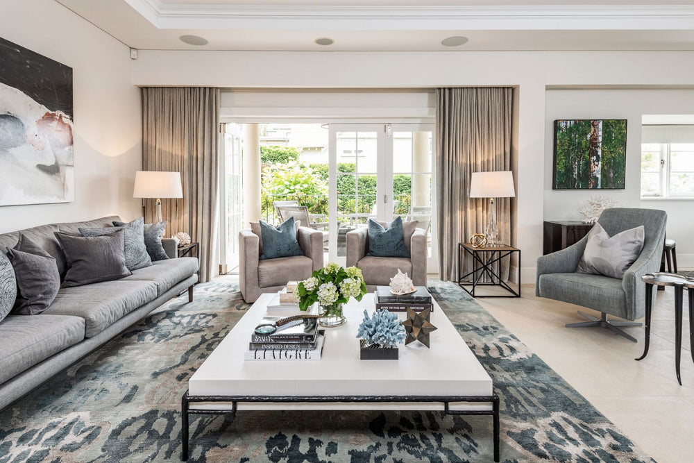 Living room with grey upholstered seating, curtains and a patterned rug